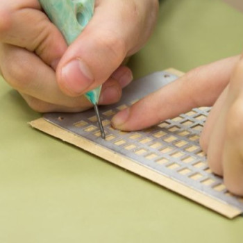 Photo of a person writing with a slate and stylus